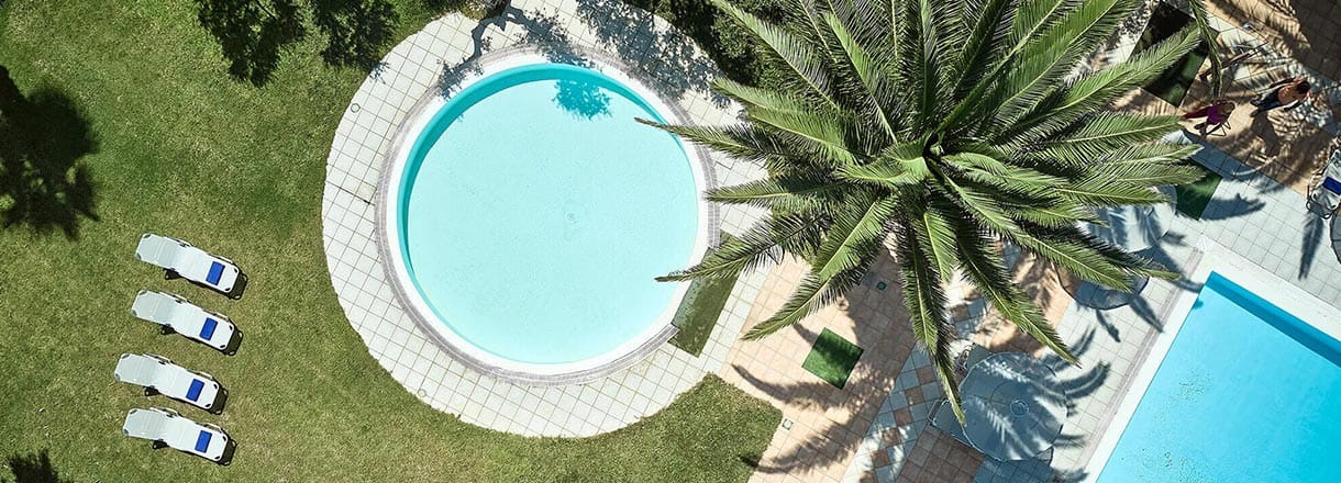 Tylissos Beach Hotel pool area with palm trees in Ierapetra Crete